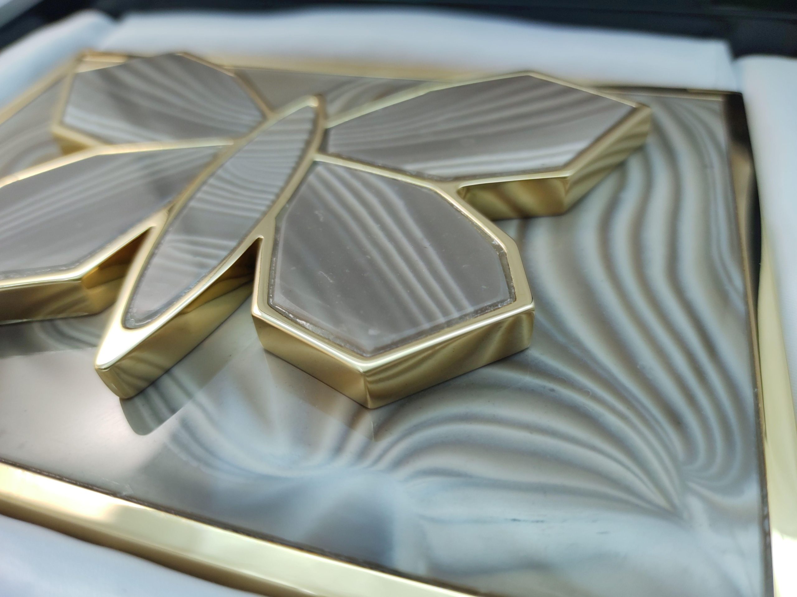 detail_luxury_gold_plated_buckle_with_rare_striped_flint_stone_for_luxurious_dress_authored_handcrafted_by_kostylo_atelier A close-up of the luxurious buckle, plated with 23 karat gold, for dress or skirt featuring large gilt butterfly sculpture adorned with rare striped flint. All handcrafted at Kostylo atelier