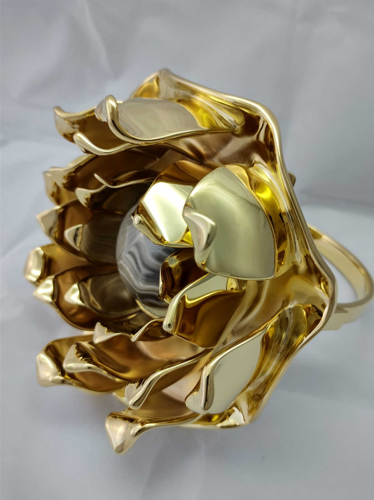 A very original figure of a lotus flower ring, gilded with pure gold with petals that protect the stone of optimism, striped flint, perfect for a luxury home and a great gift by kostylo atelier