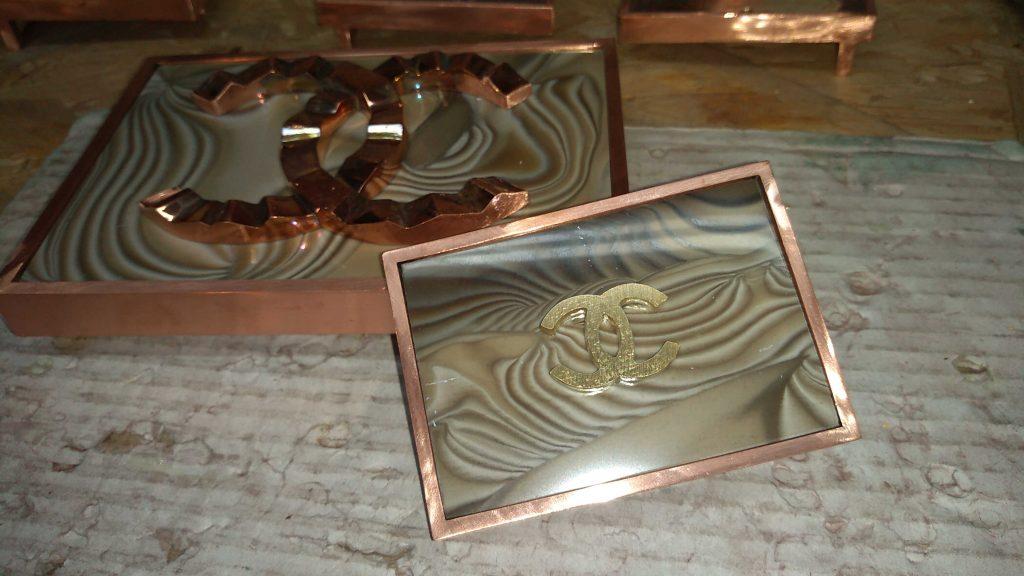 copper-plated belt buckles along with carefully fitted unique and rare striped flint stones and the coco chanel logo are handcrafted by the Kostylo atelier before being gilded