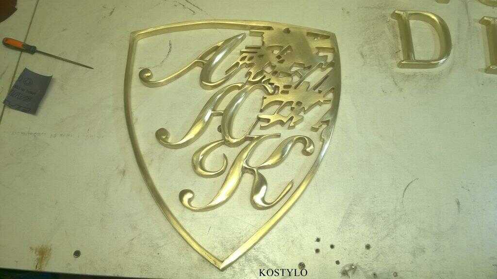 brass-cast elements of an exclusive openwork company bas-relief are hand-ground with files and smoothed with sandpaper to prepare for silver soldering and polishing in Kostylo atelier