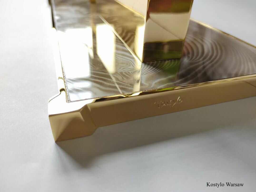 luxurious_gold_plated_modern_inkwell_with_unique_striped_flint_by_kostylo_atelier A close-up shot of a luxurious inkwell gilded with pure 23-carat gold featuring a stunning, uniquely patterned striped flint stone high-quality, handcrafted in Kostylo atelier