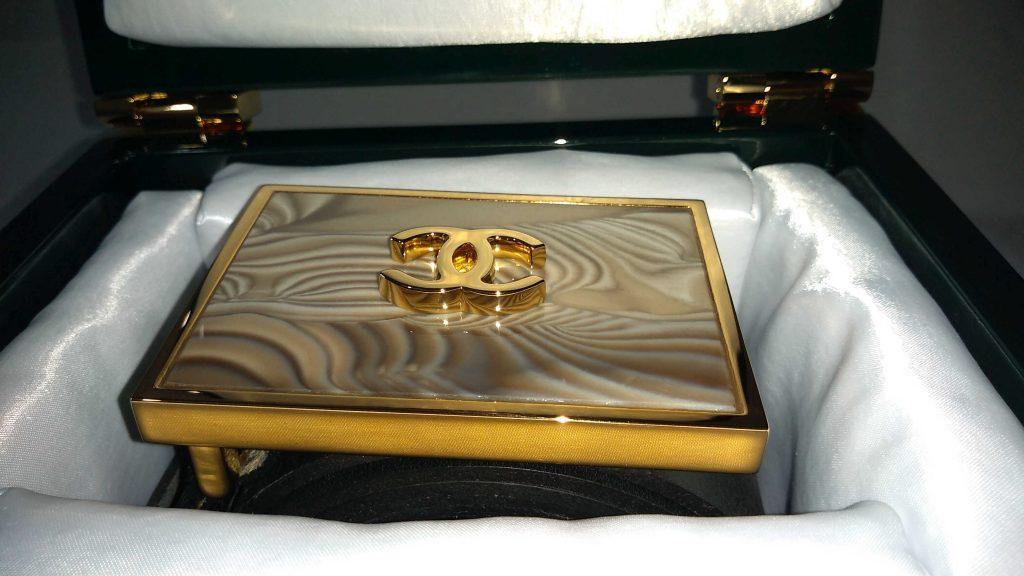 luxurious_italian_23_carat_gold_shiny_trouser_belt_buckle_with_striped_flint_rarer_than_diamond_by_kostylo_atelier Detail of luxurious trouser buckle with the Coco Chanel logo, made of shiny 23-carat gold, featuring rare as diamond striped flint, handcrafted by Kostylo atelier, presented in branded box lined with satin