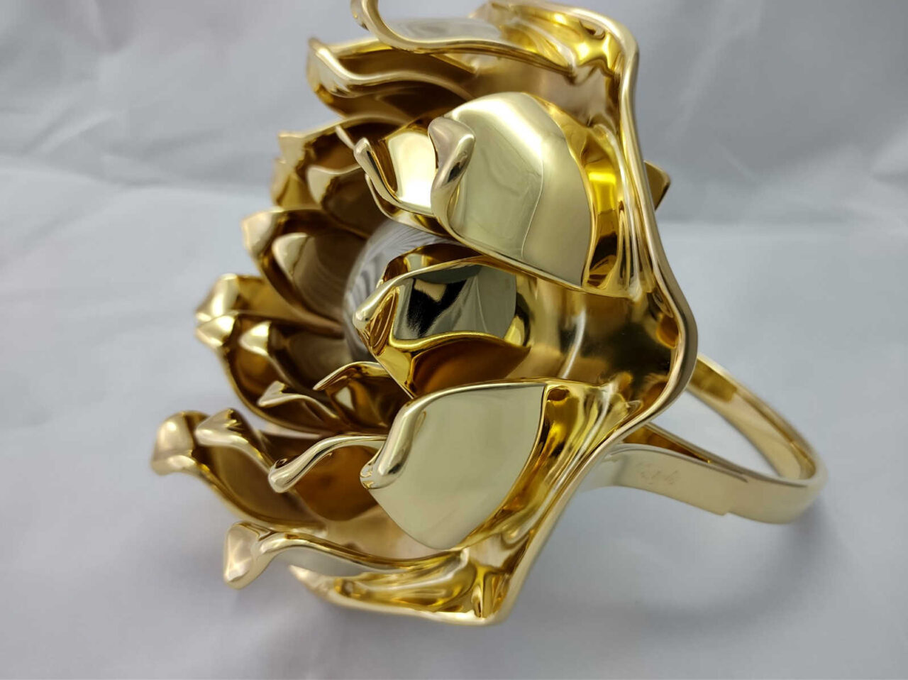 Original and beautiful ring sculpture in the shape of a lotus flower, gilded with 23-karat gold, featuring handcrafted petals protecting a striped flint stone of optimism by Kostylo atelier