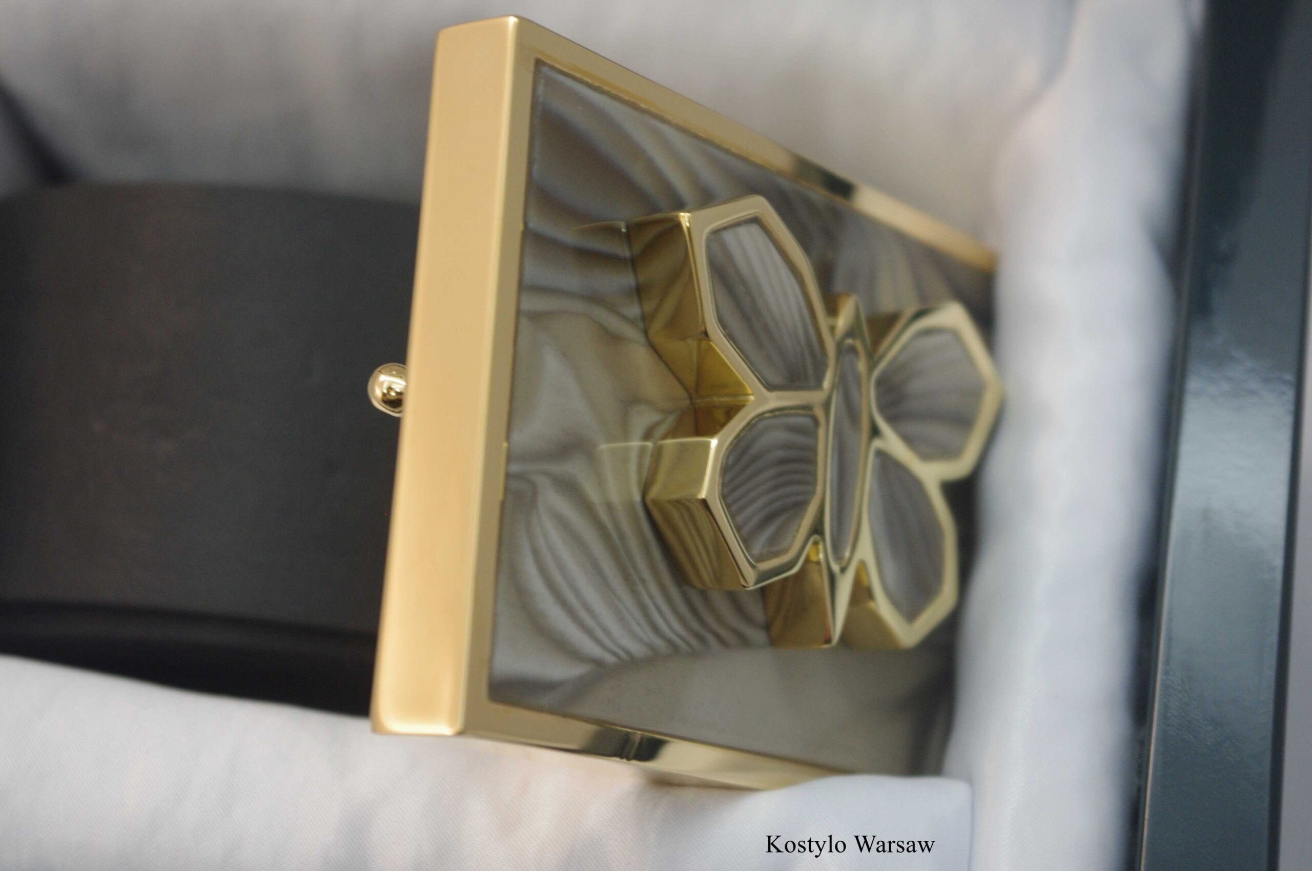 luxury_gilded_belt_buckle_for_woman_by_kostylo_atelier close-up angle of luxury gold-plated belt buckle featuring an original sculpture of butterfly gilded with italian pure gold and embellished with rare striped flint stone of optimism, handcrafted by the Kostylo atelier