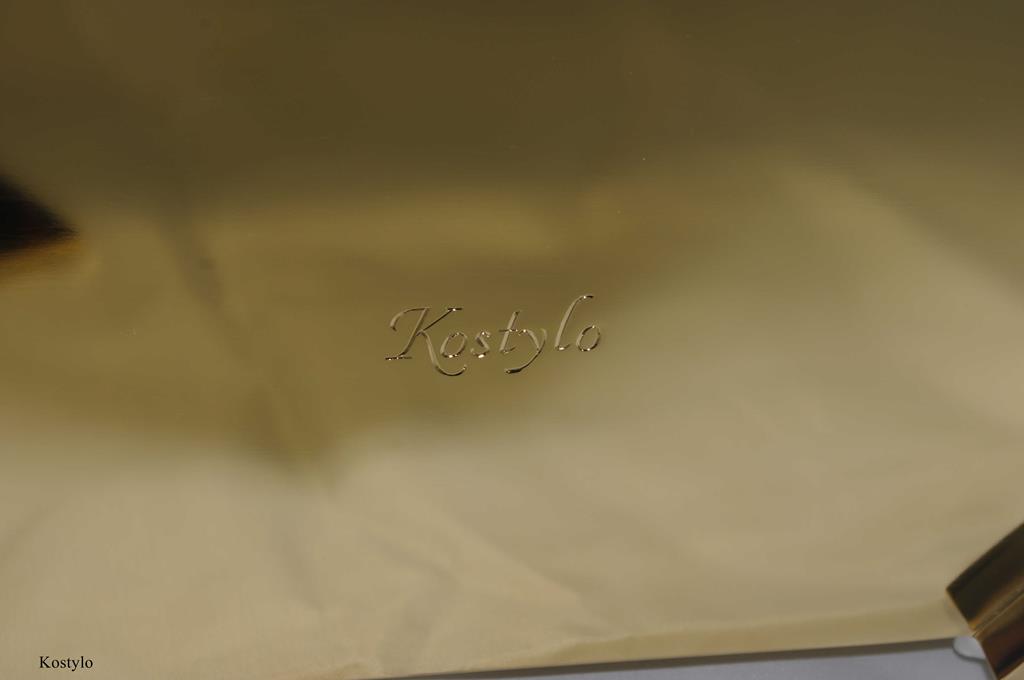 close-up of the bottom of luxurious jewelry box gilded with 23-carat bright gold, featuring the hand-engraved Kostylo logo