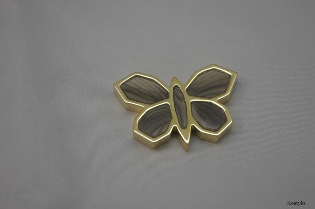 Stunning close-up of the luxury butterfly bas-relief gilded in Italian gold and set with semi-precious striped flint stone with beautiful patterning by Kostylo atelier